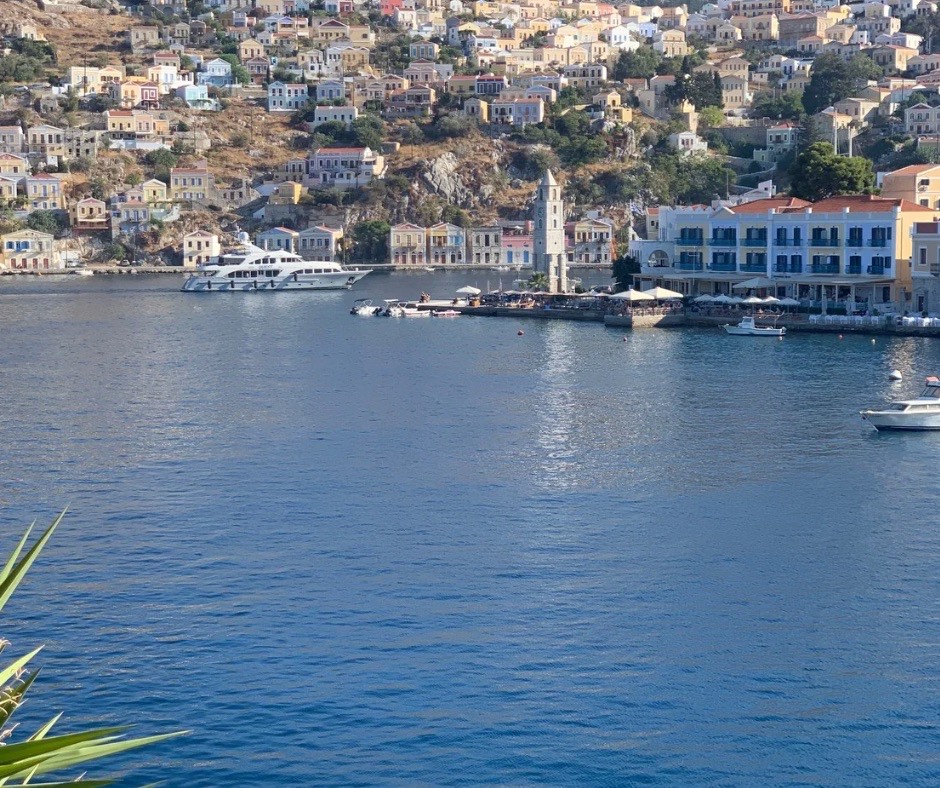 Udsigt over havnen i Symi by med klokketårn og både