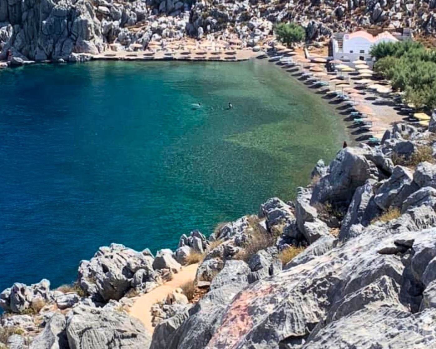 Udsigt over en idyllisk klippebugt med krystalklart vand på Symi